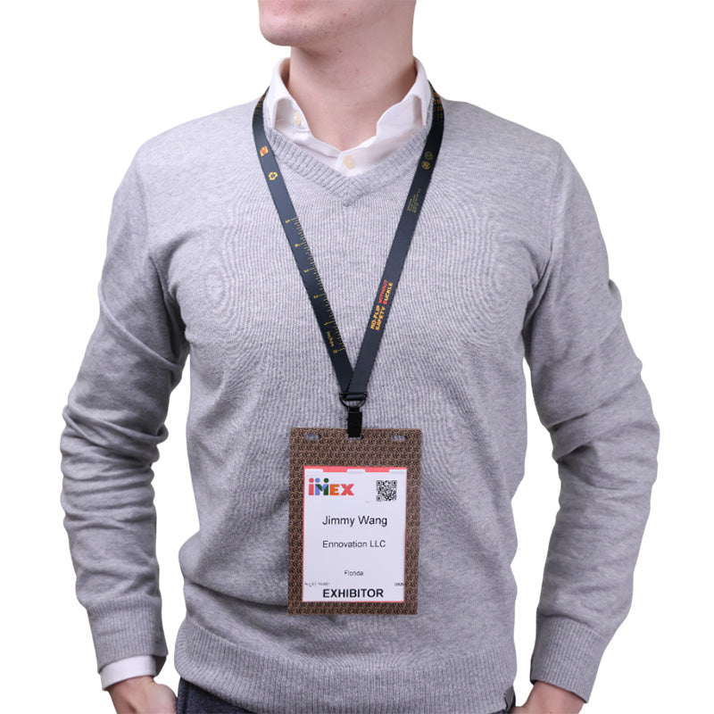 Person wearing a gray sweater with a name tag on a white background